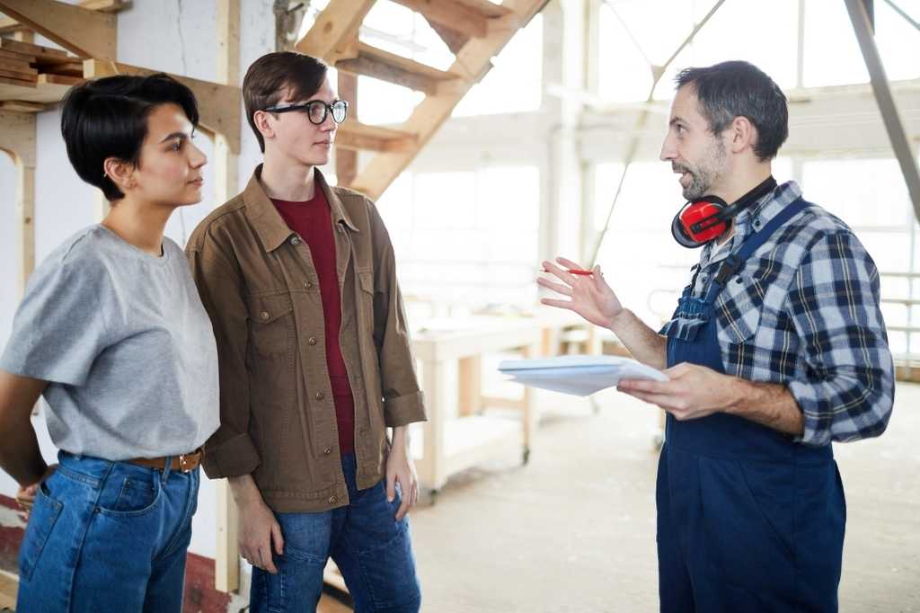 Young Couple Speaking to a Builder | Featured image for Questions to Ask Builder Before Renovating | Blog